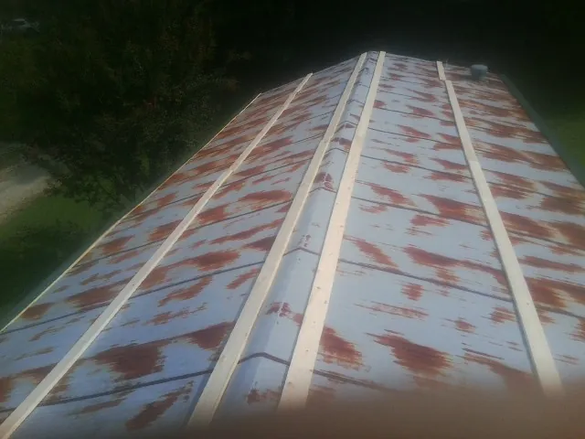 Rusted metal roof panels with new wood purlins before replacement — Storm Damage Roof Repair in Guild by Roofing Brothers