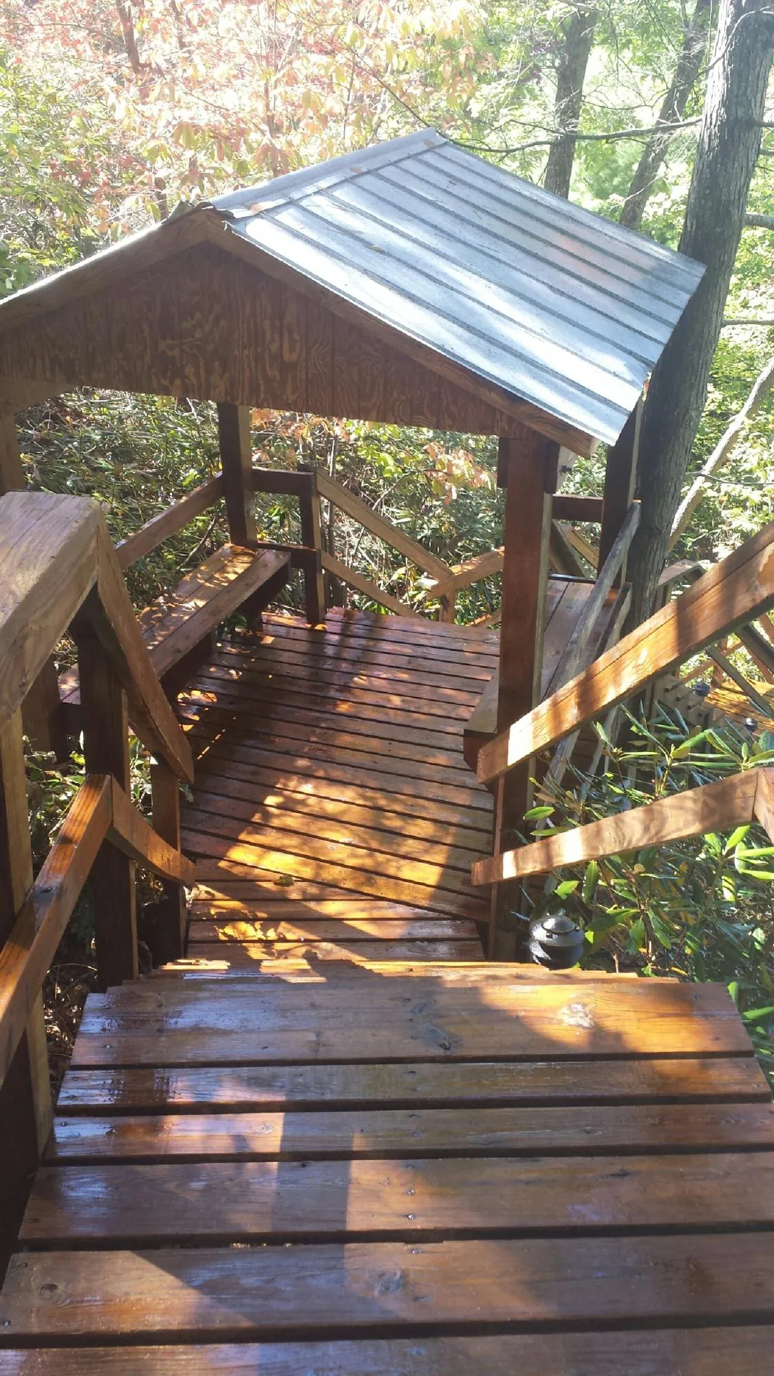 Freshly stained wood walkway and covered shelter with a metal roof in Guild