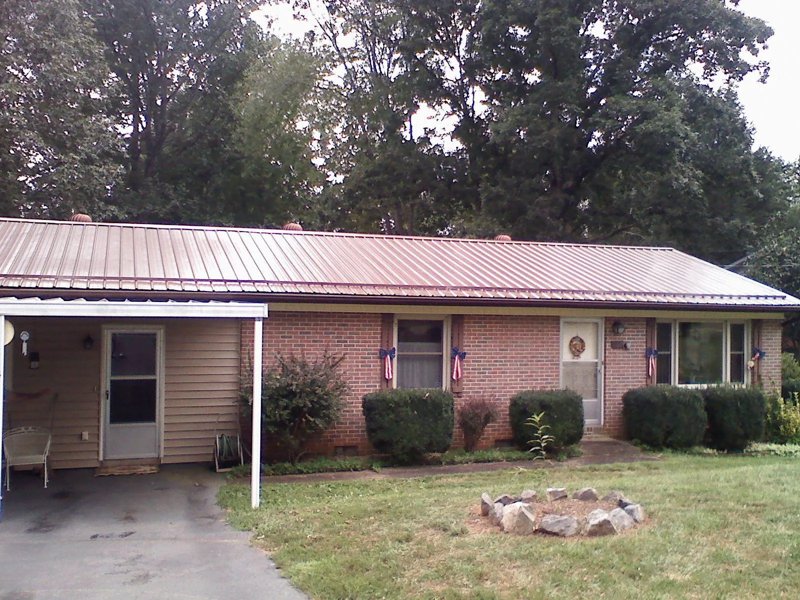 Bronze metal roof and carport on a brick ranch home — Roof Repair work by our crew in Guild